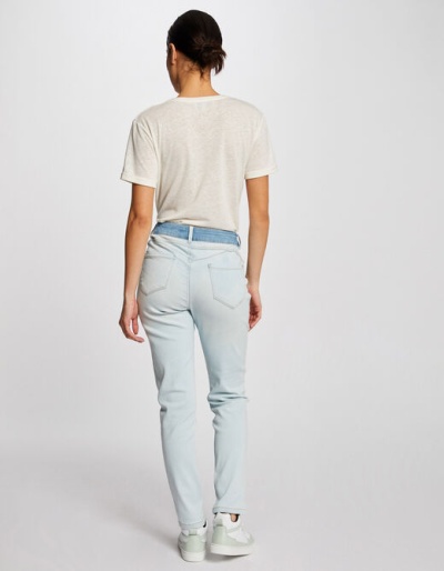 Pessoa de costas com t-shirt branca e calças de ganga azul clara