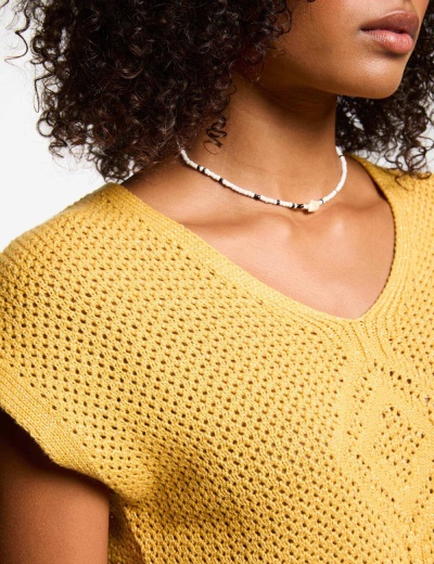 Blusa amarela de malha com padrão de pontos abertos e decote em V