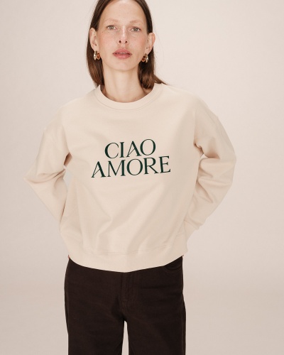 Mulher a usar sweatshirt bege com texto 