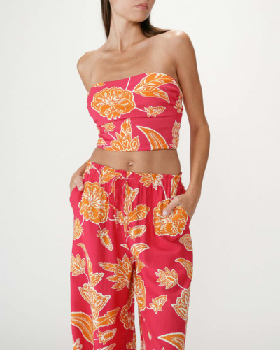 Conjunto feminino vermelho com padrão floral laranja e branco, top tomara que caia e calças largas com cintura elástica.