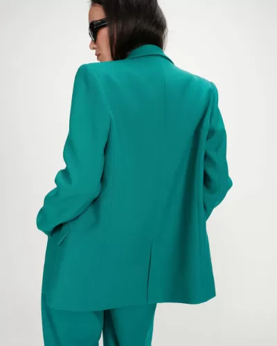Blazer verde feminino com calças verdes e óculos de sol