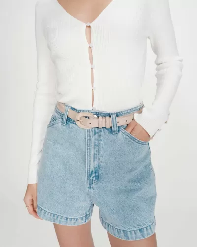 Calções de ganga azul claro com cinto bege e camisola branca de malha canelada