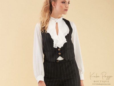 Mulher vestindo conjunto feminino com camisa branca e colete preto risca de giz