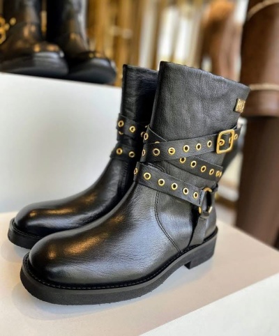 Botas pretas de pele com correias e fivela em exposição