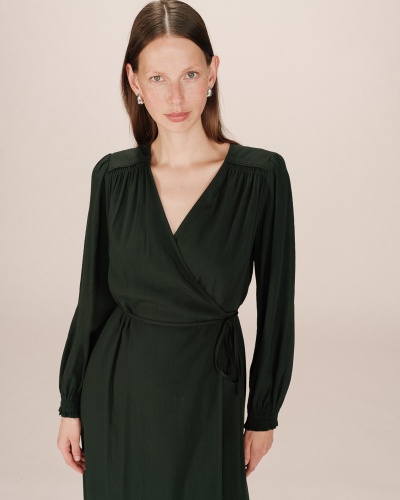 Vestido preto de manga comprida com cinto fino e gola em V.