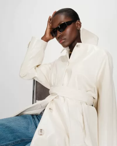 Casaco branco brilhante com cinto e óculos de sol pretos