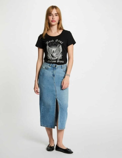 Mulher com t-shirt preta estampada e saia midi de ganga azul