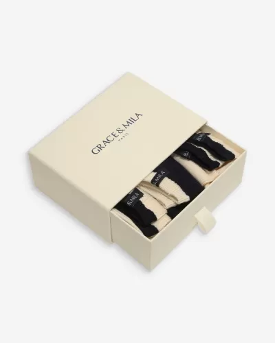Caixa bege com texto GRACE & MILA PARIS contendo meias bege e pretas