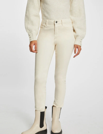 Calças justas creme usadas com botas creme e camisola de malha creme