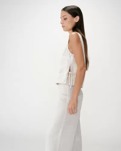 Conjunto feminino bege claro de linho composto por top sem mangas com laço lateral e calças compridas retas.