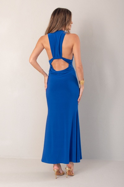 Vestido comprido azul com costas abertas e recorte usado por mulher em fundo branco.