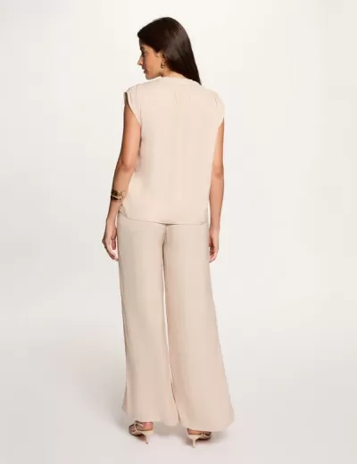 Conjunto feminino bege claro com blusa sem mangas e calças largas visto de costas