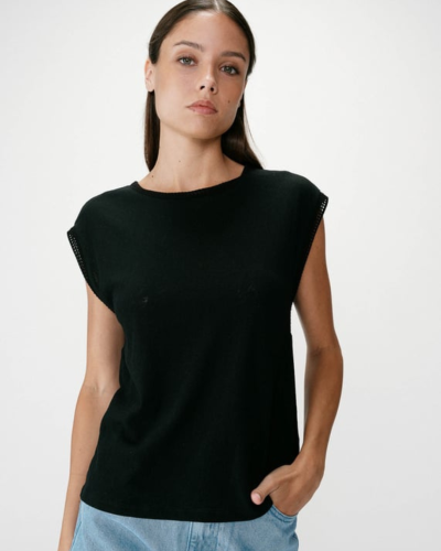 Mulher a usar t-shirt preta sem mangas e calças azuis claras