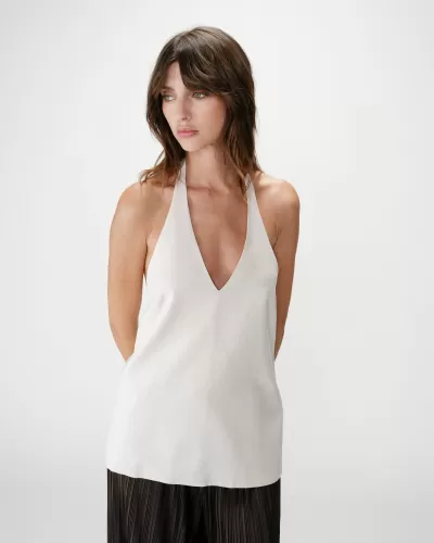 Blusa branca decote em V com calças pretas plissadas em fundo branco