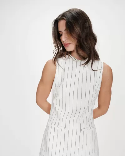 Vestido branco riscado verticalmente com colar de pérolas