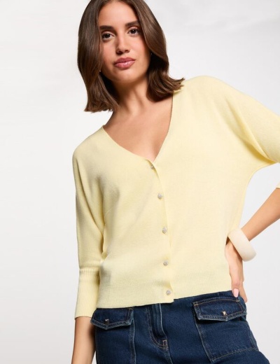 Cardigan amarelo claro com botões brilhantes e calças de ganga azul