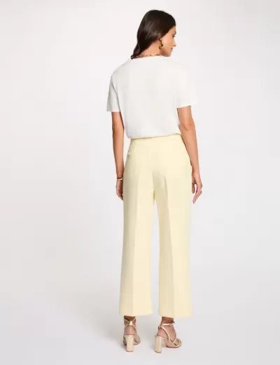 Mulher com t-shirt branca e calças amarelas de costas