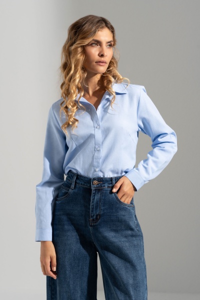 Mulher com blusa de ganga azul clara e calças de ganga azul escura