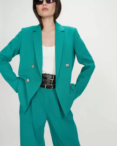 Conjunto feminino verde com blazer e calças, top branco e óculos escuros