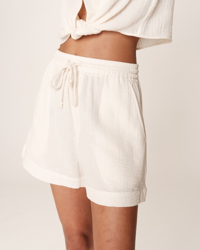 Shorts brancos com cintura elástica e cordão, tecido texturizado.