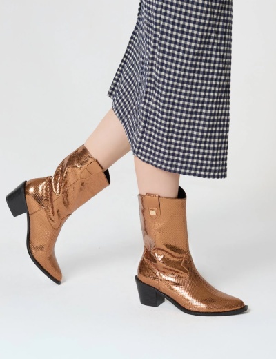 Botas douradas com padrão cobra, salto médio em bloco, usadas com saia xadrez