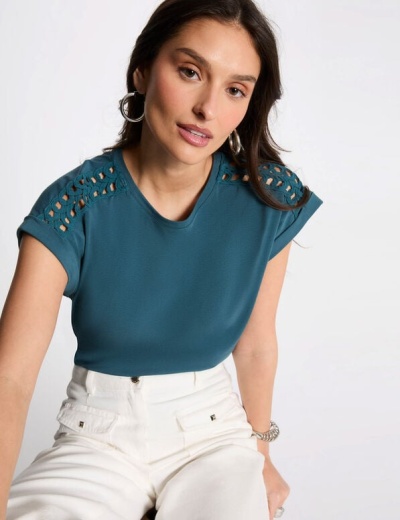 T-shirt azul-petróleo com recortes nos ombros e calças brancas