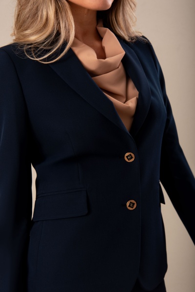 Blazer azul escuro com botões castanhos e camisa bege com gola drapeada