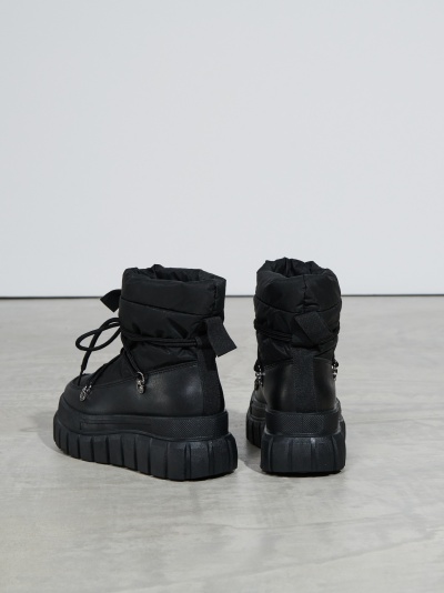 Botas pretas com sola grossa e parte superior almofadada