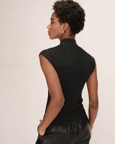 Mulher de costas com blusa preta de malha e calças pretas