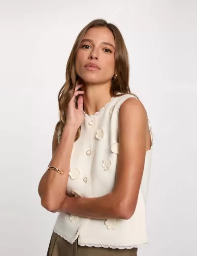 Camisa de alças branca com flores em relevo e botões frontais.