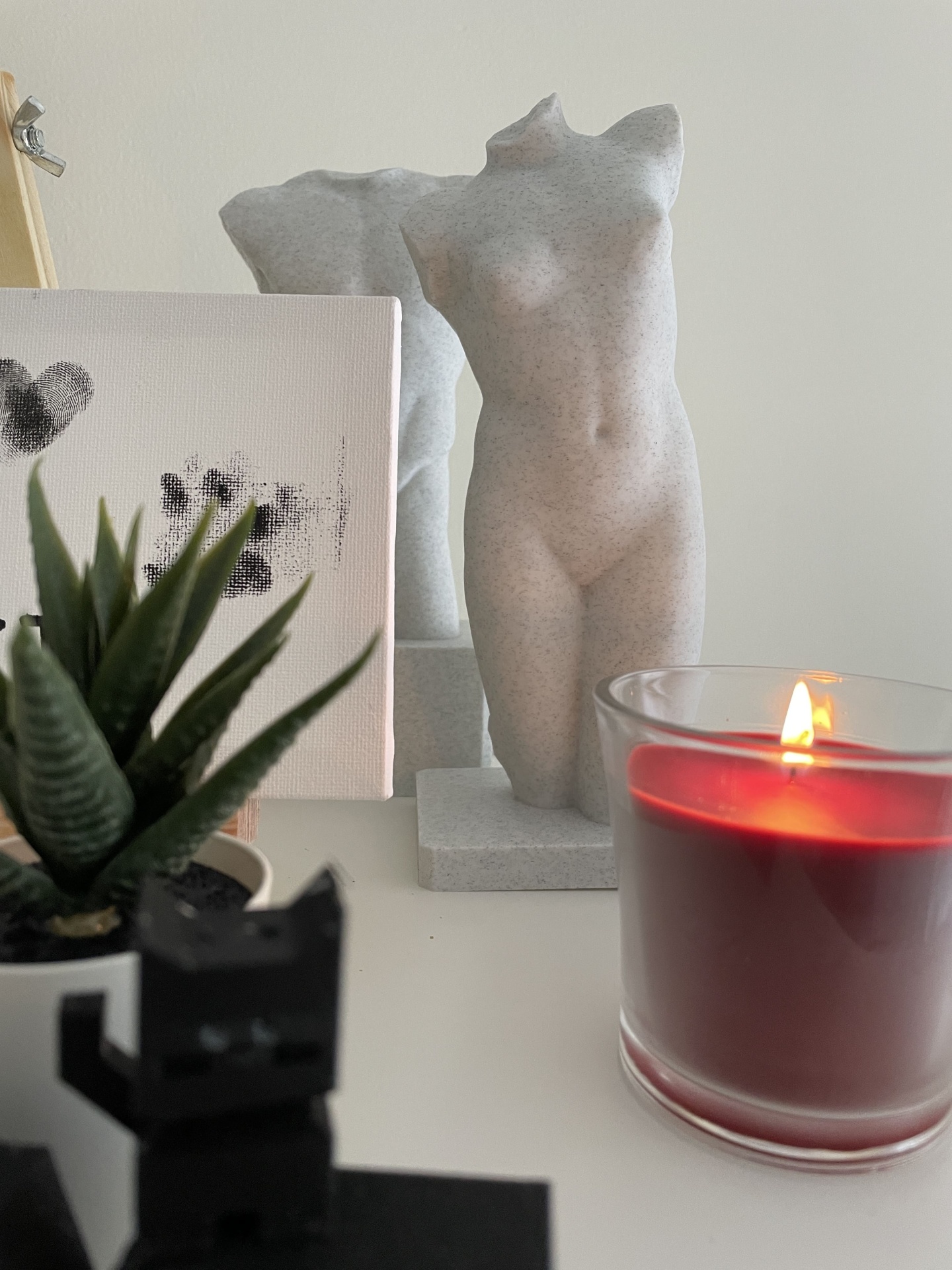 Serviço de Impressão 3D Personalizada – Transforme seus Modelos Digitais em Realidade Escultura de torso feminino cinza com vela vermelha e planta sobre mesa branca