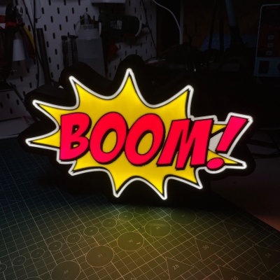 Placa luminosa decorativa com a palavra BOOM! em amarelo e vermelho