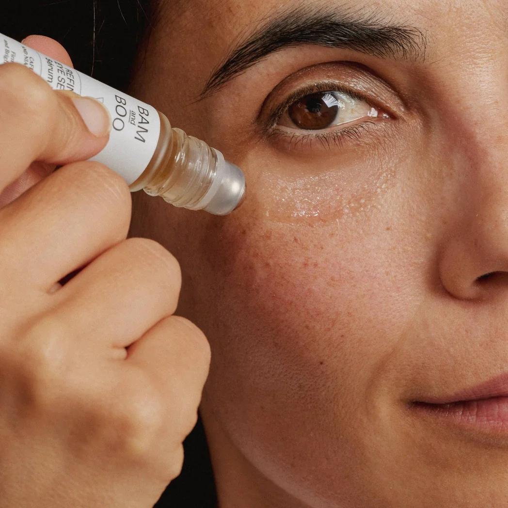 Frasco pequeno de vidro com aplicador metálico e rótulo branco BAM and BOO aplicado no rosto