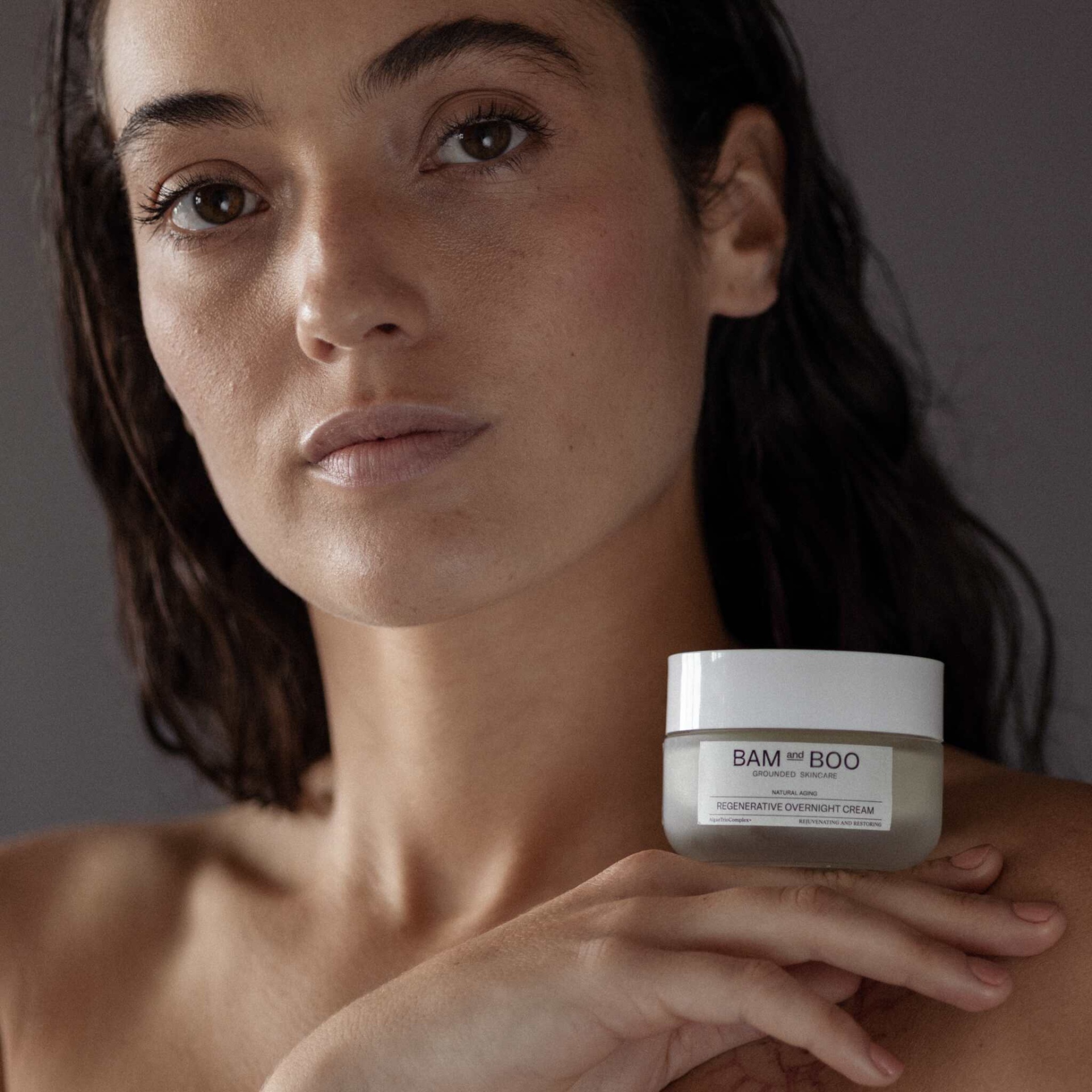 Frasco de creme regenerador noturno BAM and BOO na mão de mulher