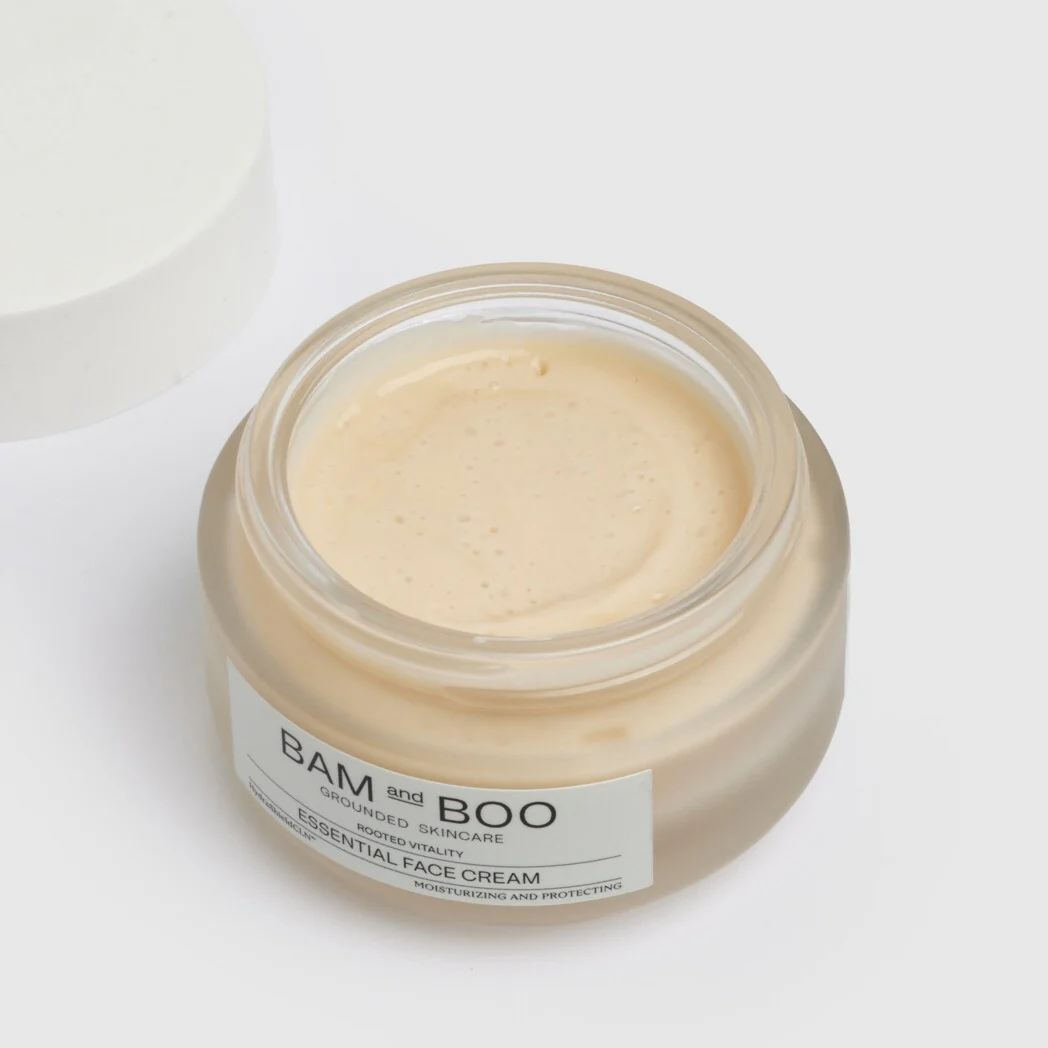 Frasco de vidro fosco com creme facial bege e tampa branca removida