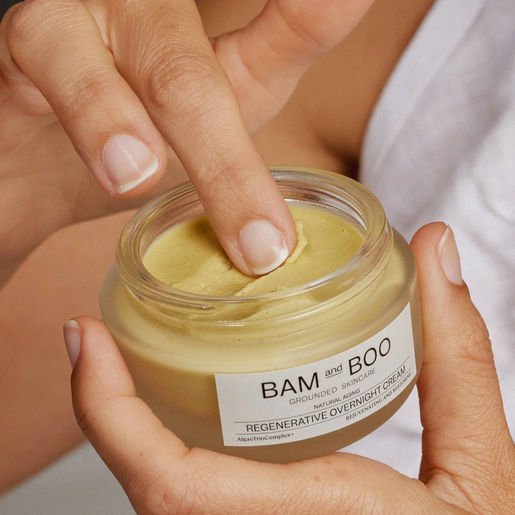 Frasco de creme regenerativo noturno BAM and BOO com aplicação de creme ao dedo