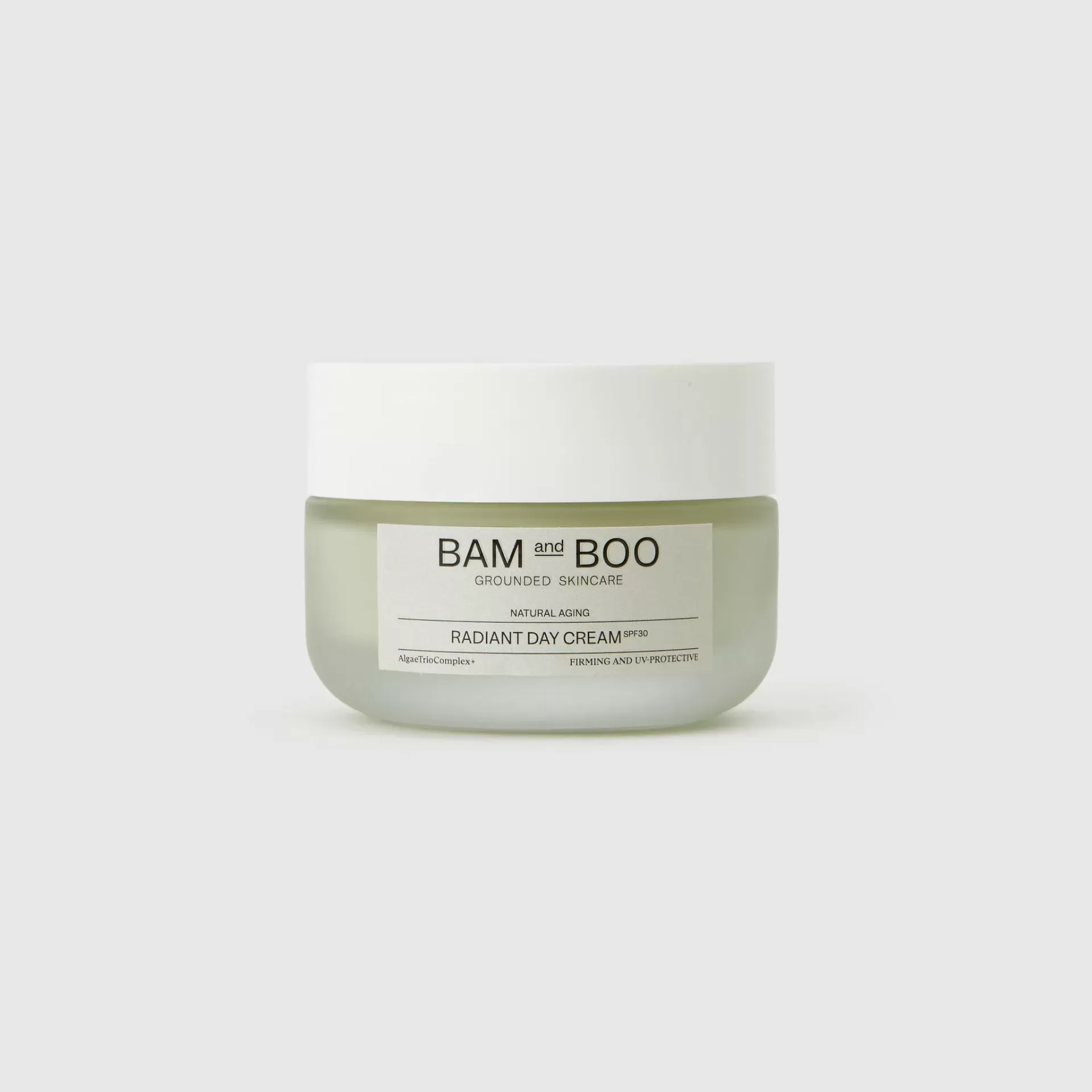 Frasco de vidro verde com tampa branca de creme da marca BAM and BOO