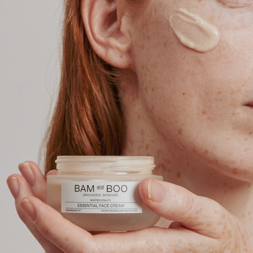 Frasco de creme facial BAM and BOO com creme aplicado no rosto