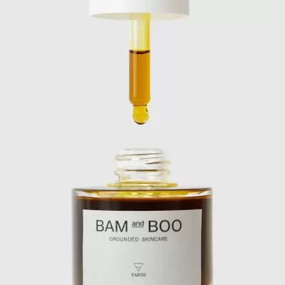 Conta-gotas com líquido amarelo sobre frasco de vidro castanho com rótulo BAM and BOO