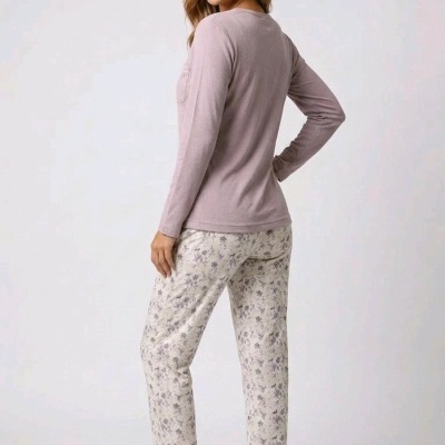 Mulher de pijama rosa com calças florais e chinelos bege
