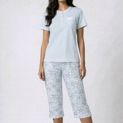 Mulher a usar conjunto de pijama azul claro e branco com padrão floral.