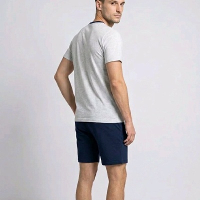 Homem de costas com t-shirt cinzenta e calções azul escuro