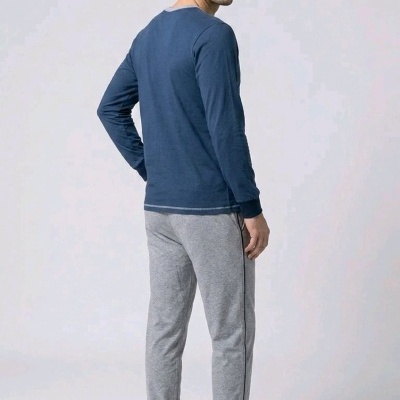 Homem de costas com roupa de pijama azul e cinza