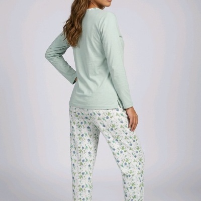 Mulher de pé com pijama verde claro e calças florais brancas