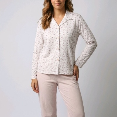 Mulher a usar conjunto de pijama com camisa de botões branca com flores cor-de-rosa e calças rosa claro