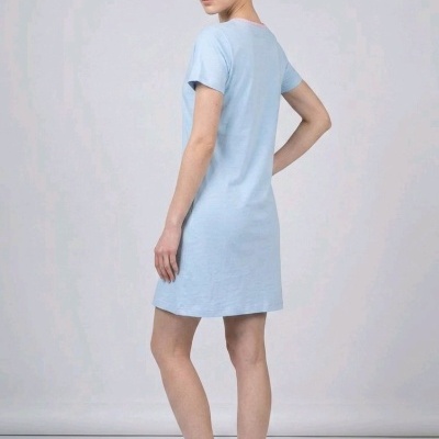 Vestido curto azul claro de manga curta com gola rosa, usado por modelo com chinelos rosa claro