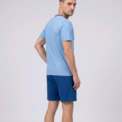 Homem de costas com t-shirt azul clara e calções azuis
