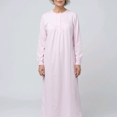 Mulher com vestido rosa claro e chinelos cinza
