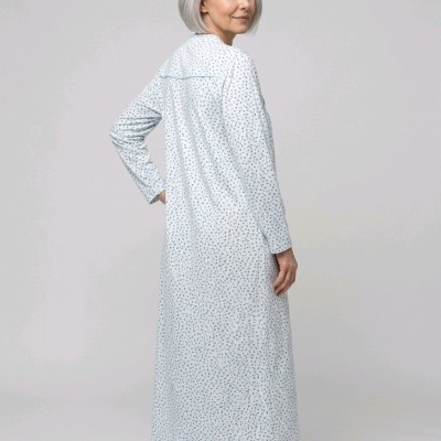 Mulher de costas com chemise de noite branca com padrão floral azul
