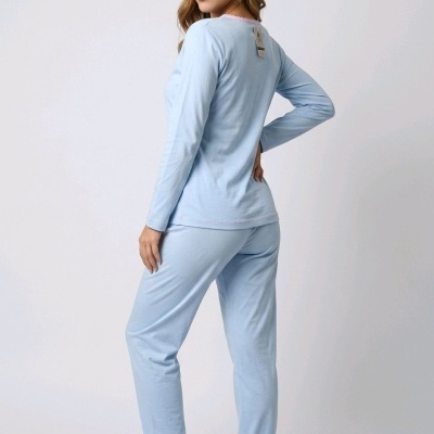 Mulher vestindo conjunto de pijama azul claro com chinelos da mesma cor